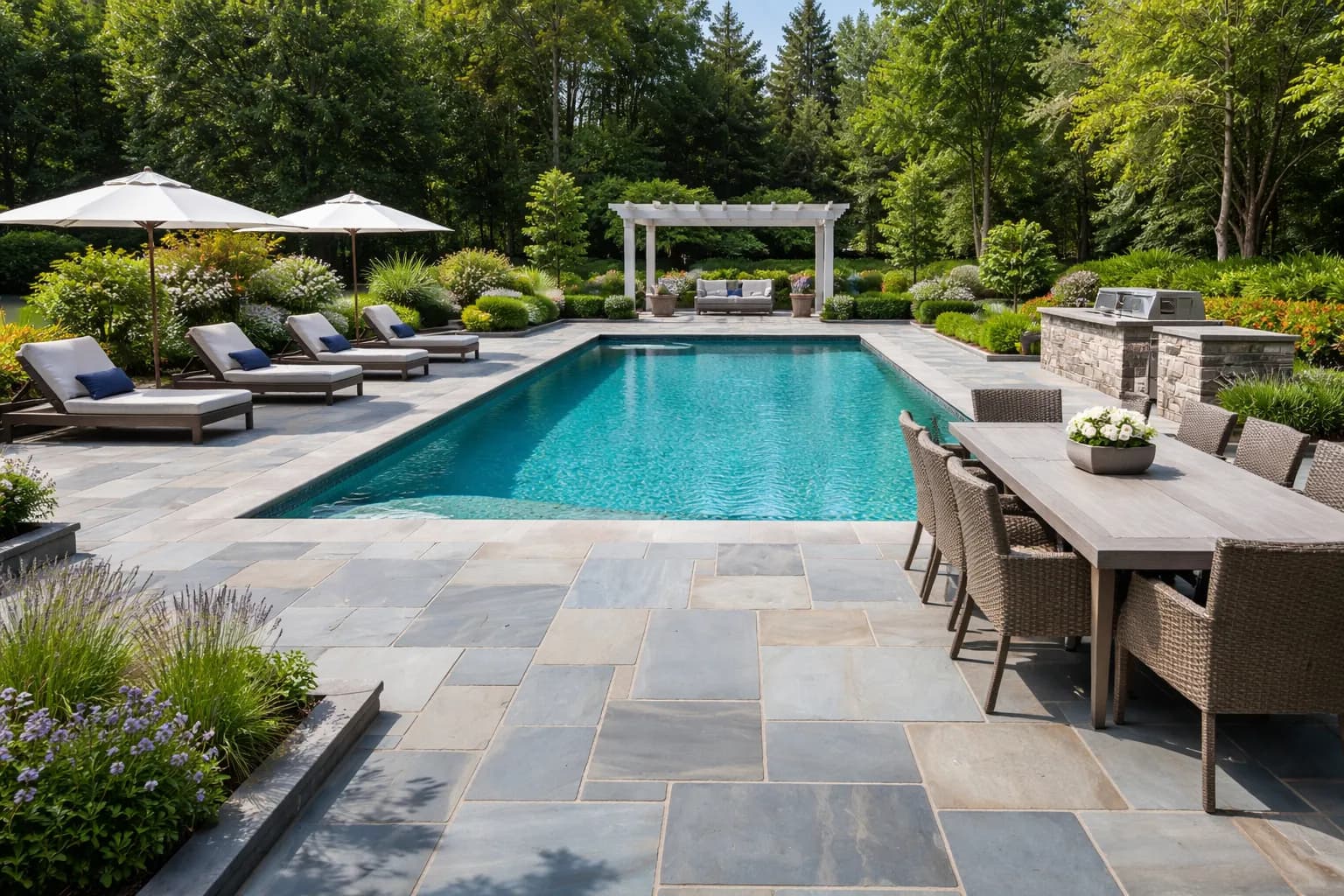 Bluestone patio with pergola beside a custom pool