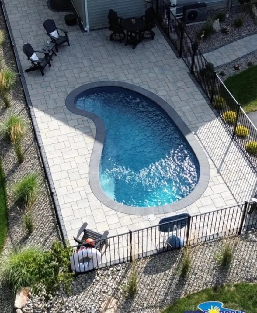 Freeform fiberglass pool with paver patio installed by Flynn Pools and Patios
